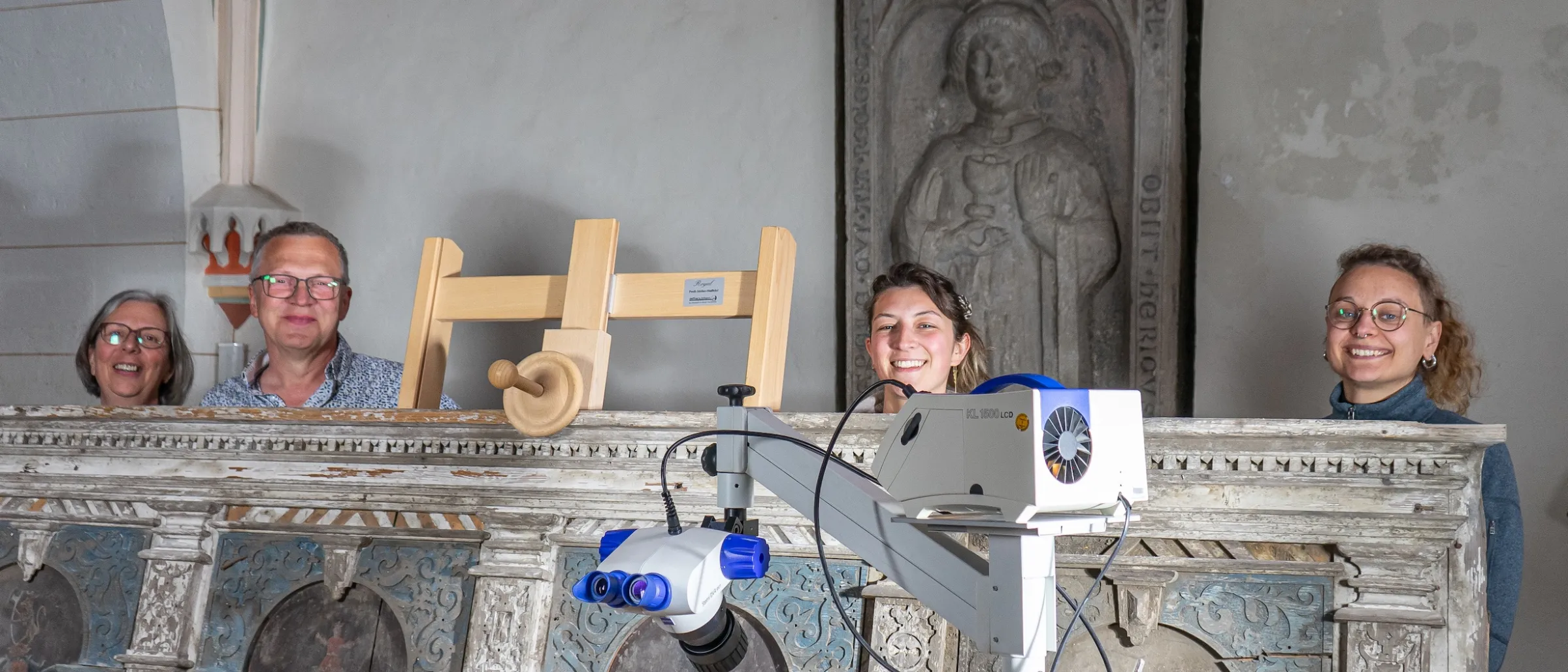 Hinter der Tafel: Ina Birkenbeul, Dr. Ralf Buchholz, Sophia Niebel, Pauline Böttcher – vor der Tafel: ein Stereomikroskop