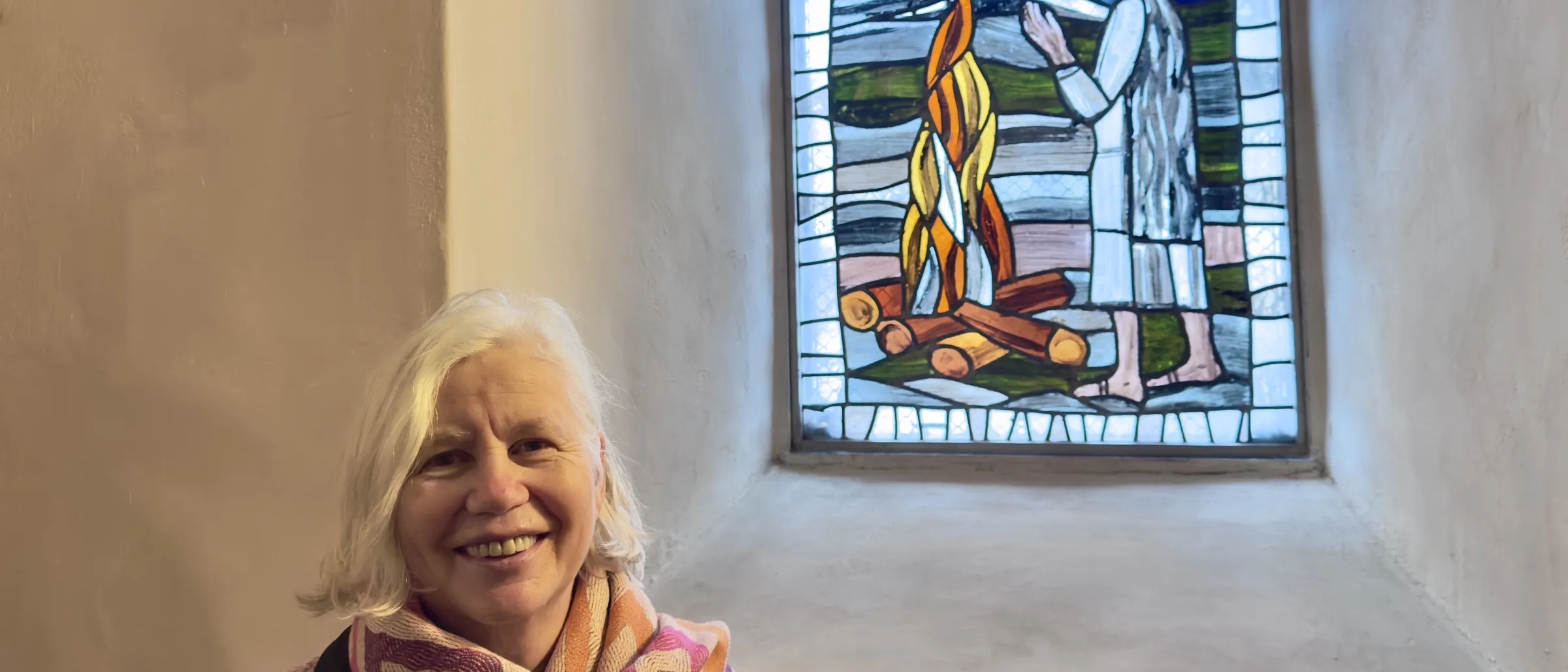 Dorothee Wallner, Tochter von Claus Wallner, steht in der Gandersheimer Stiftskirche vor dem "Noahfenster", das ihr Vater gestaltet hat.