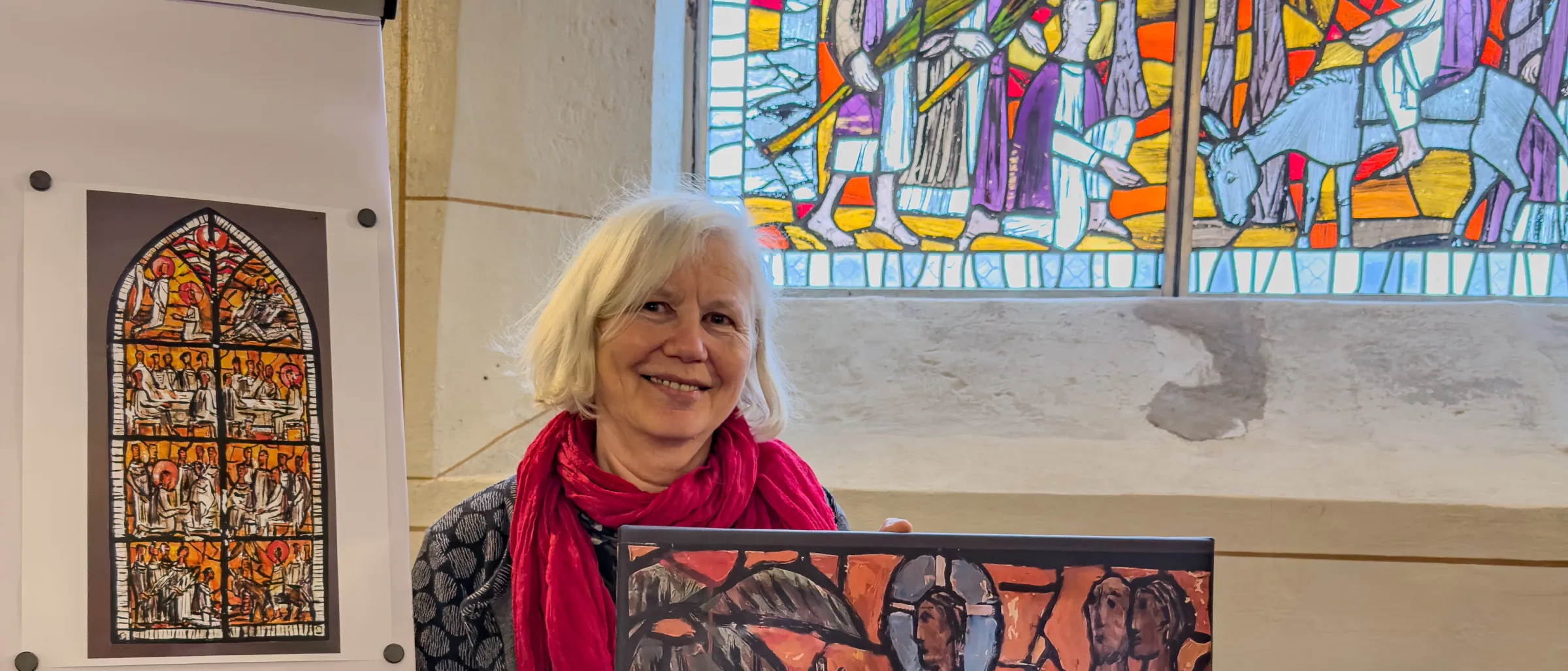 Dorothee Wallner, Tochter von Claus Wallner, steht vor dem Passionsfenster in der Kapelle St. Peter und St. Paul, das ihr Vater 1976 angefertigt hat.