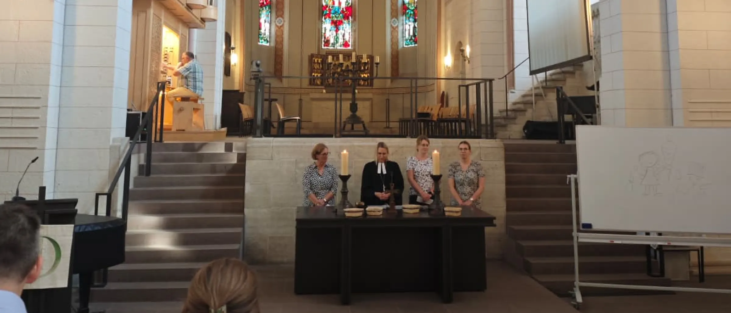 Die Lehrerinnen stehen mit Pröpstin Meike Bräuer-Ehgart am Altar und sprechen die Fürbitte