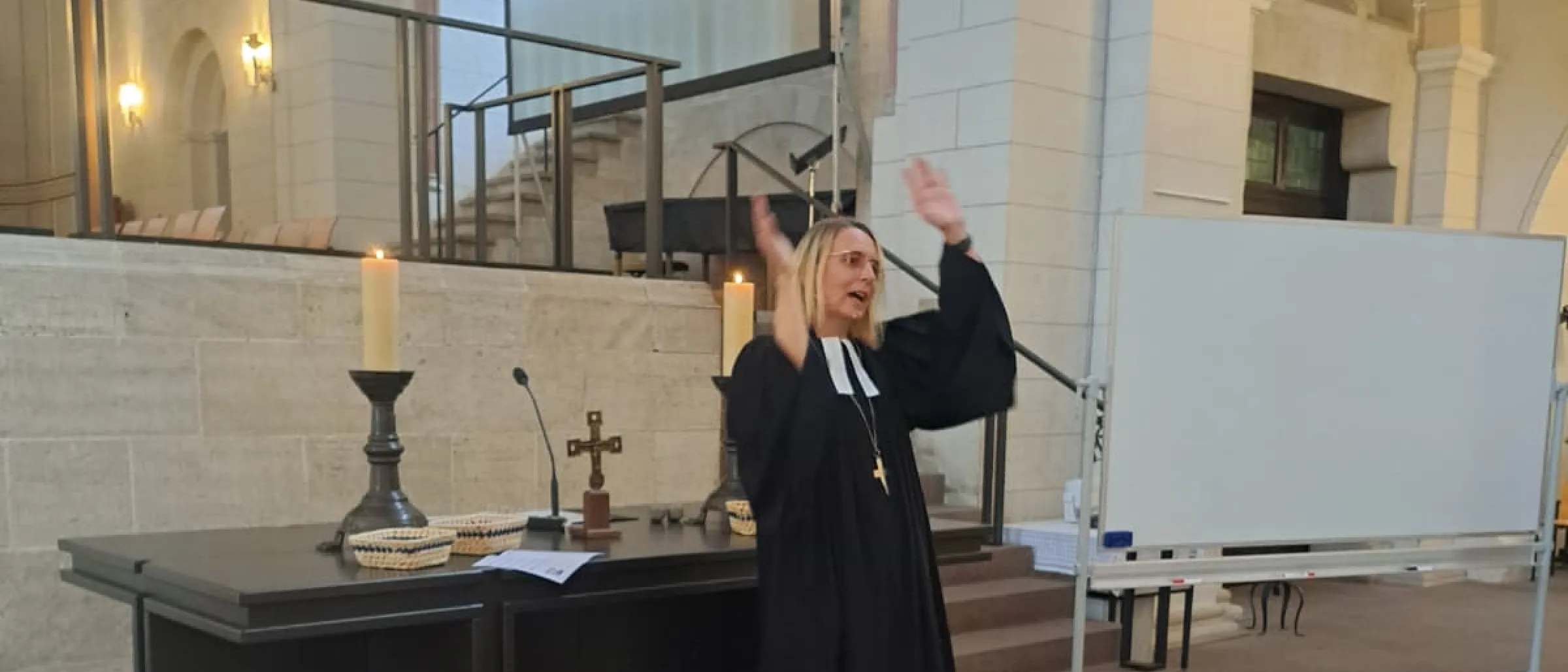 Pröpstin Meike Bräuer-Ehgart steht vor dem Altar und tanzt mit zum Lied "Einfach Spitze, dass du da bist"